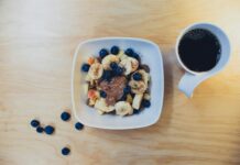 음식의 질이 건강에 미치는 영향 sliced bananas with berries and peanut butter beside cup of coffee on table