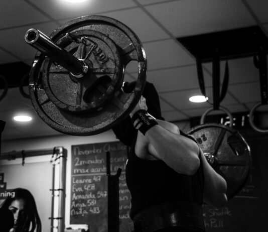 운동이 노화 방지에 미치는 효과 grayscale photo of man lifting barbell