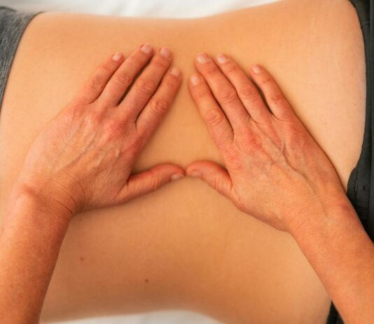 허리 통증 완화를 위한 필라테스와 식단 요법 persons hand on white textile