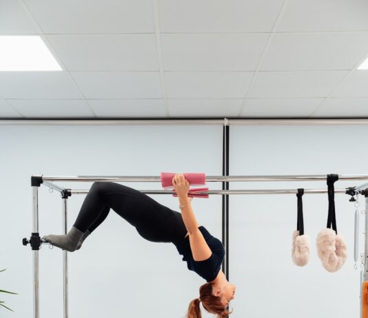 필라테스가 면역 체계를 개선하는 이유와 운동법 a woman doing a handstand on a pivot exercise