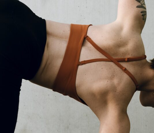 일상 속 필라테스, 건강 습관으로 자리 잡다 a woman in a brown bikini doing a handstand