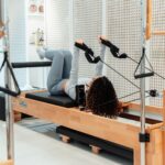 집에서도 쉽게 시작하는 필라테스, 일상 속 건강 지키기 열풍 a woman is doing exercises on a rowing machine