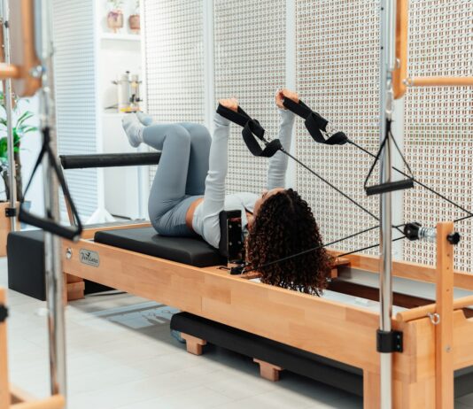 집에서도 쉽게 시작하는 필라테스, 일상 속 건강 지키기 열풍 a woman is doing exercises on a rowing machine