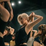 K-POP 안무로 배우는 전신 협응력: 아이돌 춤 뒤에 숨겨진 피트니스 woman in black tank top raising her hands