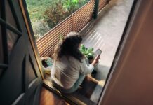 만성피로, 작은 습관 변화로 이겨내기… 한국인 맞춤 활력 찾기 전략 Woman sitting on balcony with smartphone